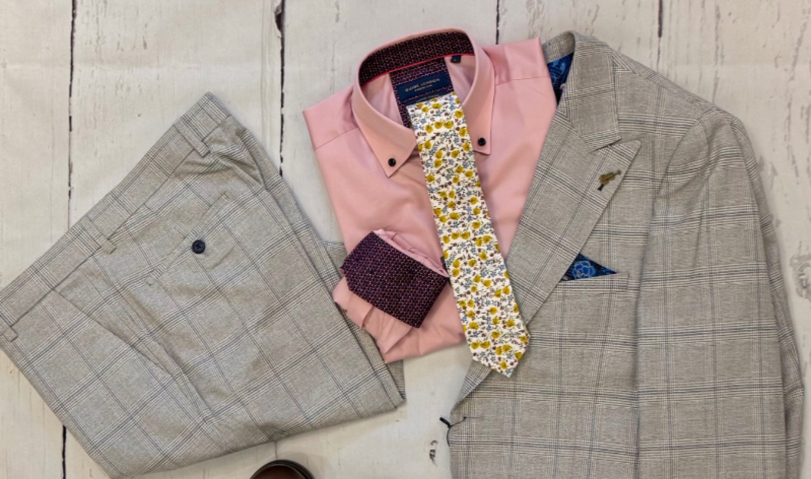 A grey suit laid out with a dress shirt and floral tie at Mr S Clothing