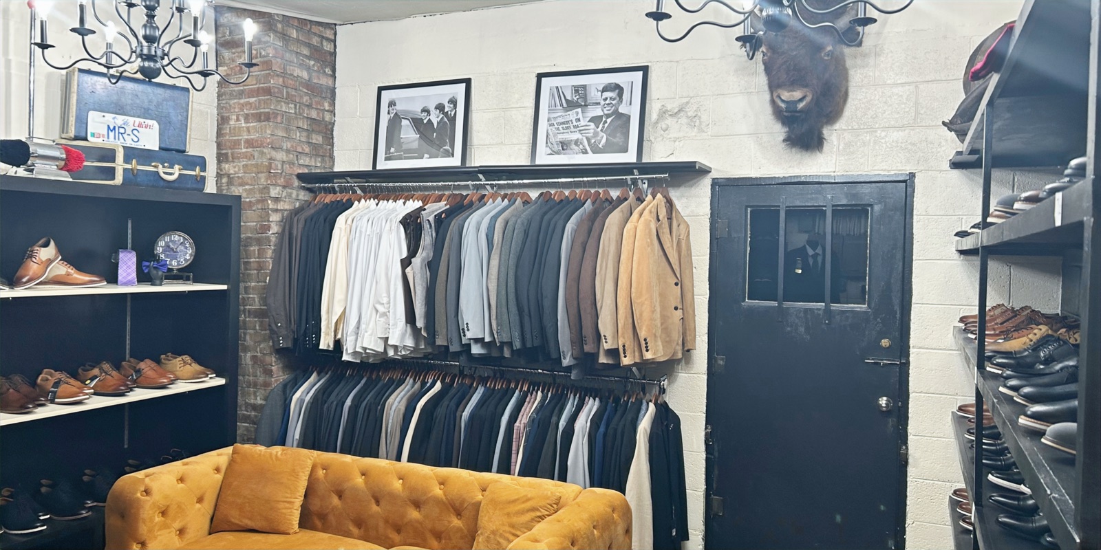 Inside Mr S Clothing: mustard velvet couch, exposed brick, iron chandelier and vintage decor